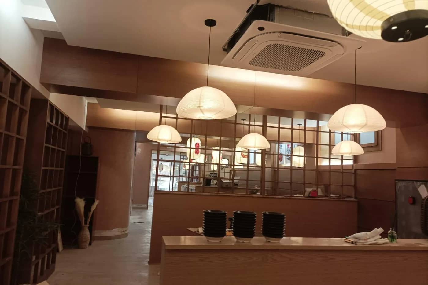 Interior de una lonja de hostelería terminada con la iluminación colgante encendida