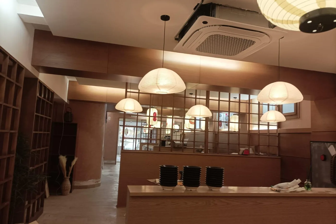 Interior de una lonja de hostelería terminada con la iluminación colgante encendida